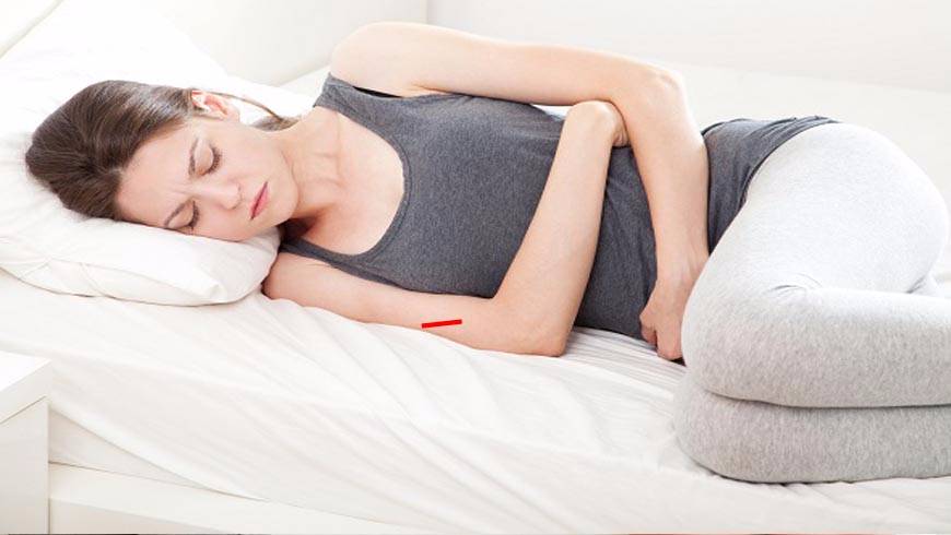 Woman lying down with pain in the abdominal area